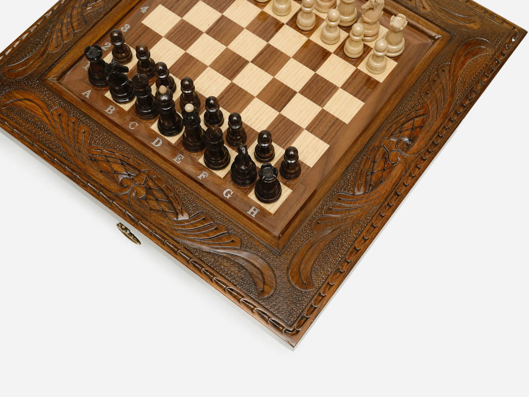 Close-up of the carved frame corner and wood chess pieces