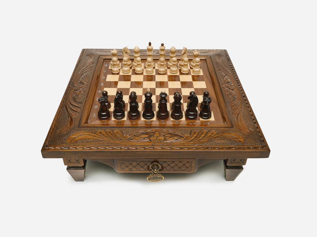 Carved chess set with classic wood pieces set up for play, front view