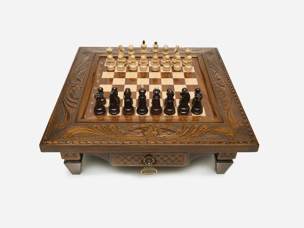 Carved chess set with classic wood pieces set up for play, front view