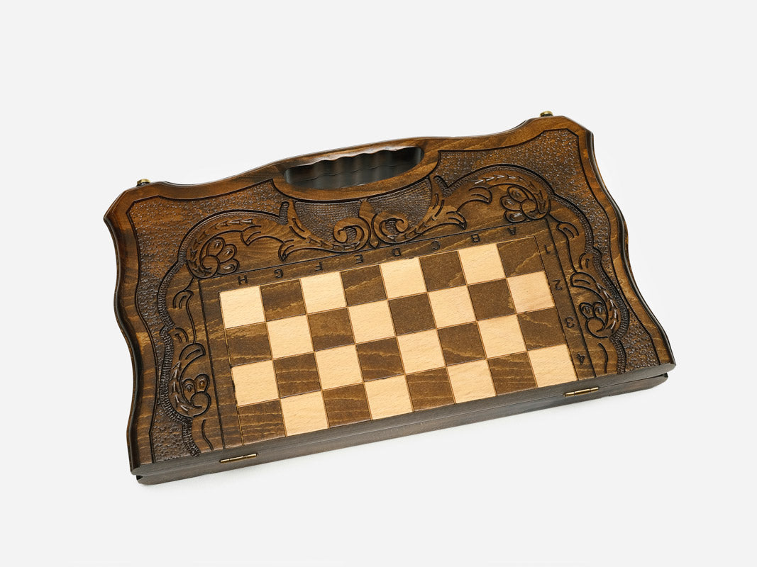 Angled view of the carved walnut chess set with its beech and walnut pieces set up