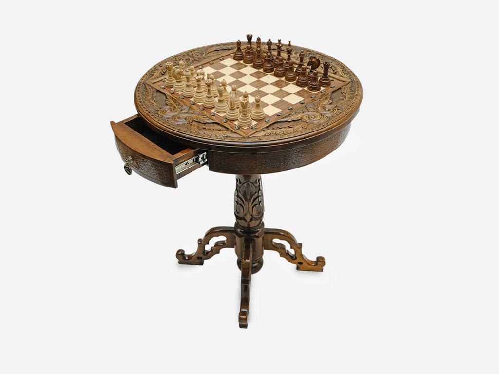 Carved wooden chess table shown at an angle with the storage drawer open