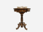 Side profile of the round carved chess table on its pedestal base