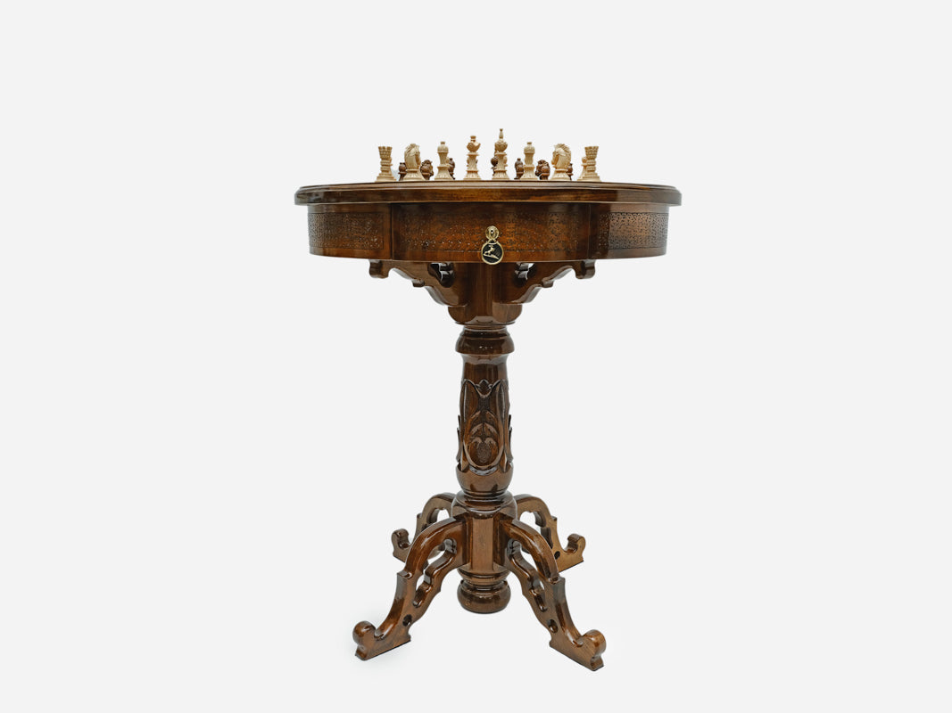 Side profile of the round carved chess table on its pedestal base