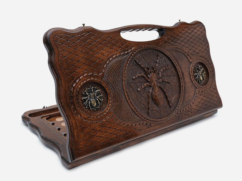 Carved beechwood backgammon board with a spider on its web and bronze details, propped open