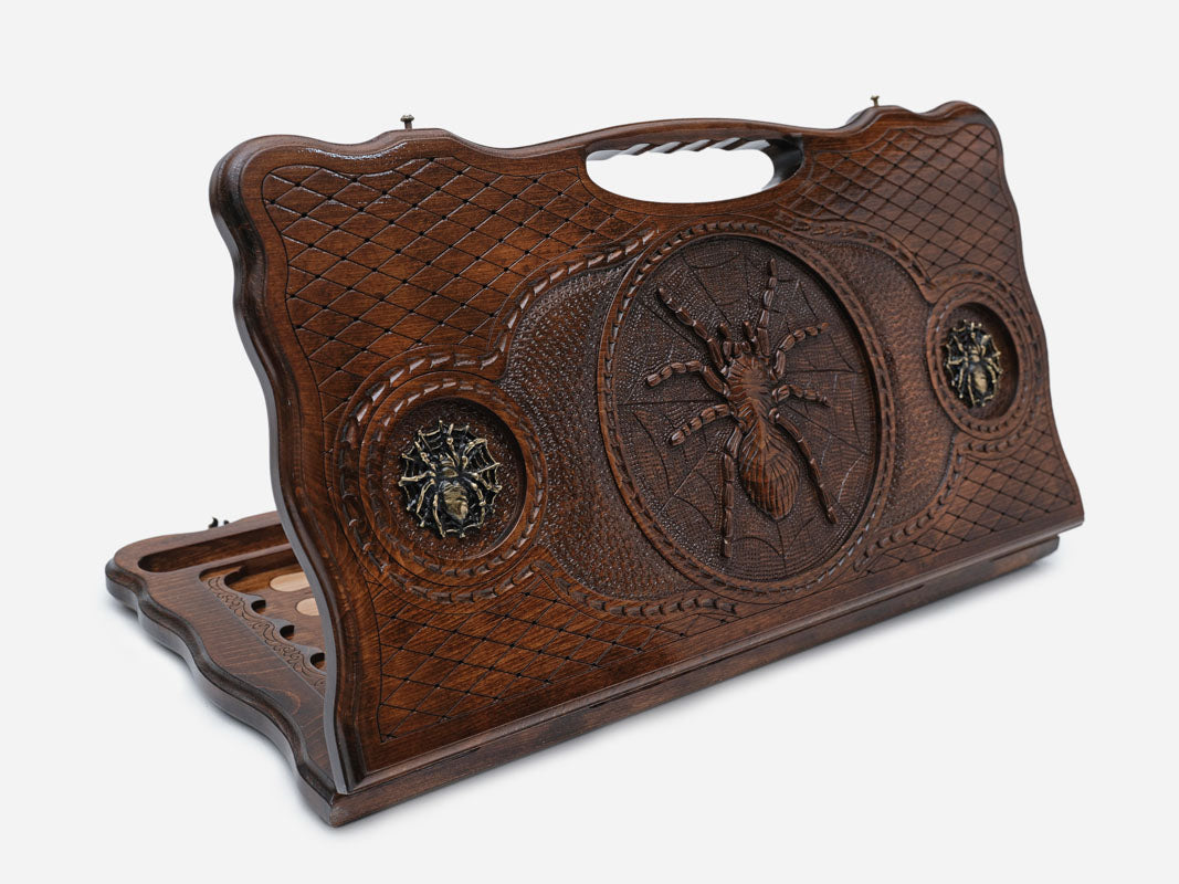 Carved beechwood backgammon board with a spider on its web and bronze details, propped open