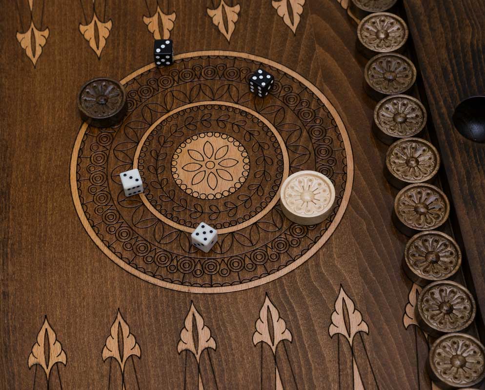 Central ornament backgammon table opened flat with checkers set up, top-down view