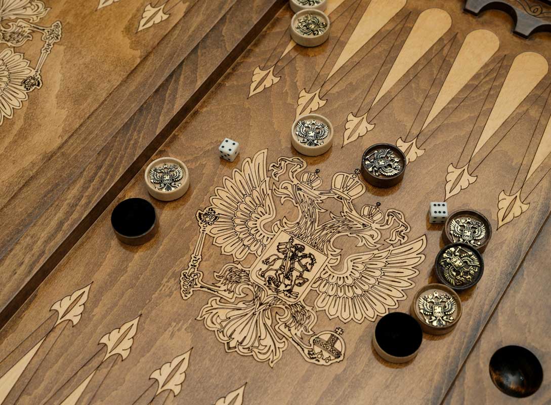 Close-up of the bronze checkers, dice and cup on the Russian coat of arms table