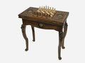 Chess and backgammon table set up for chess, angled view showing the carved lion legs