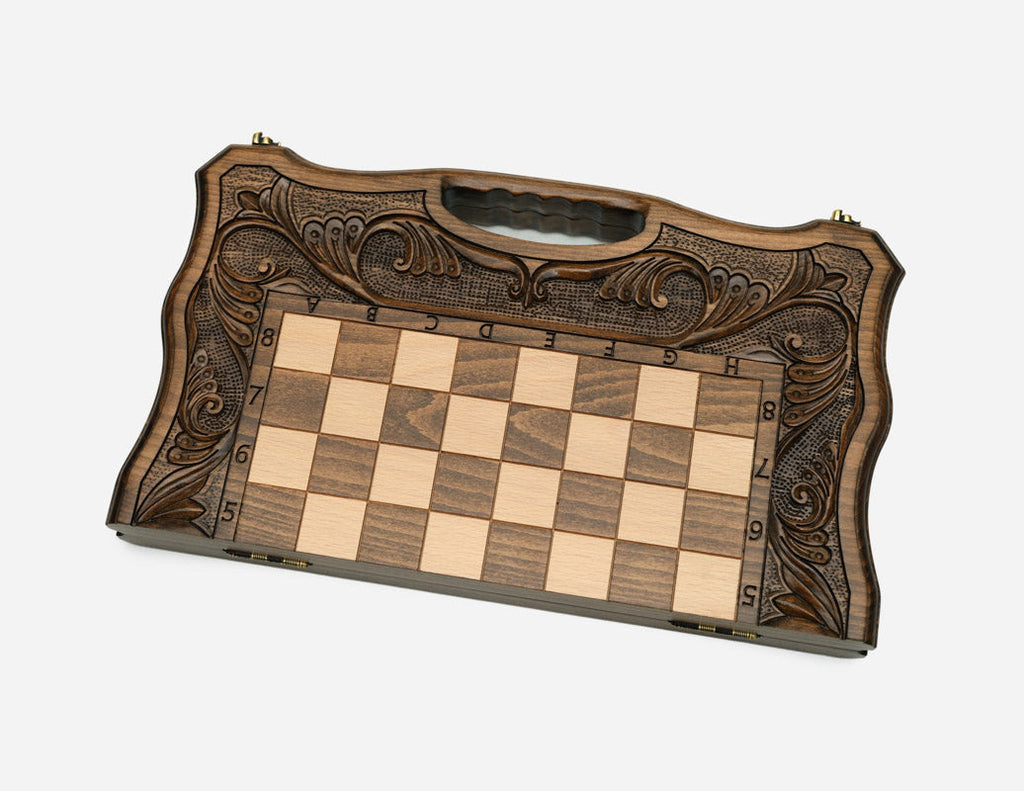 The folding chess board partly closed, showing its case form and carved handle