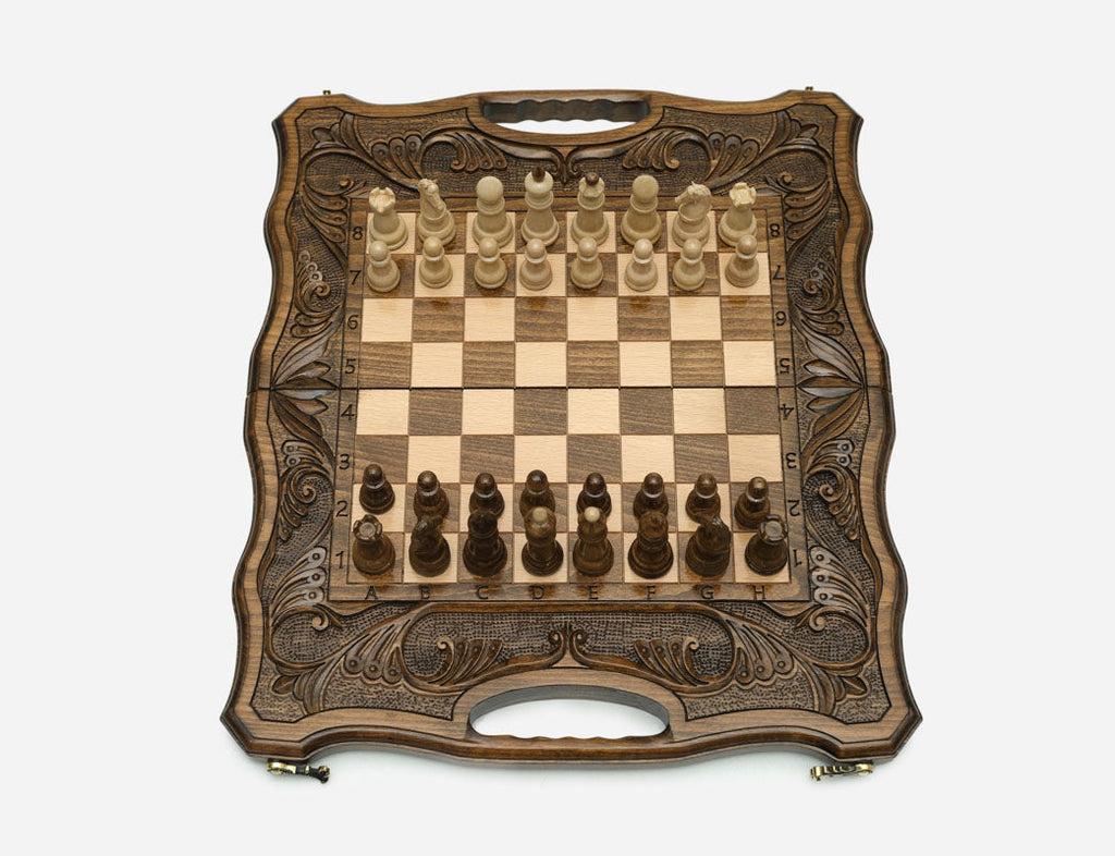 Angled view of the ornate folding chess set with its beech and walnut pieces set up