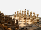 Overhead view of the carved chess board with the full set of pieces in starting position