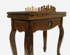 Close-up of the carved leg and drawer front with a bronze pomegranate
