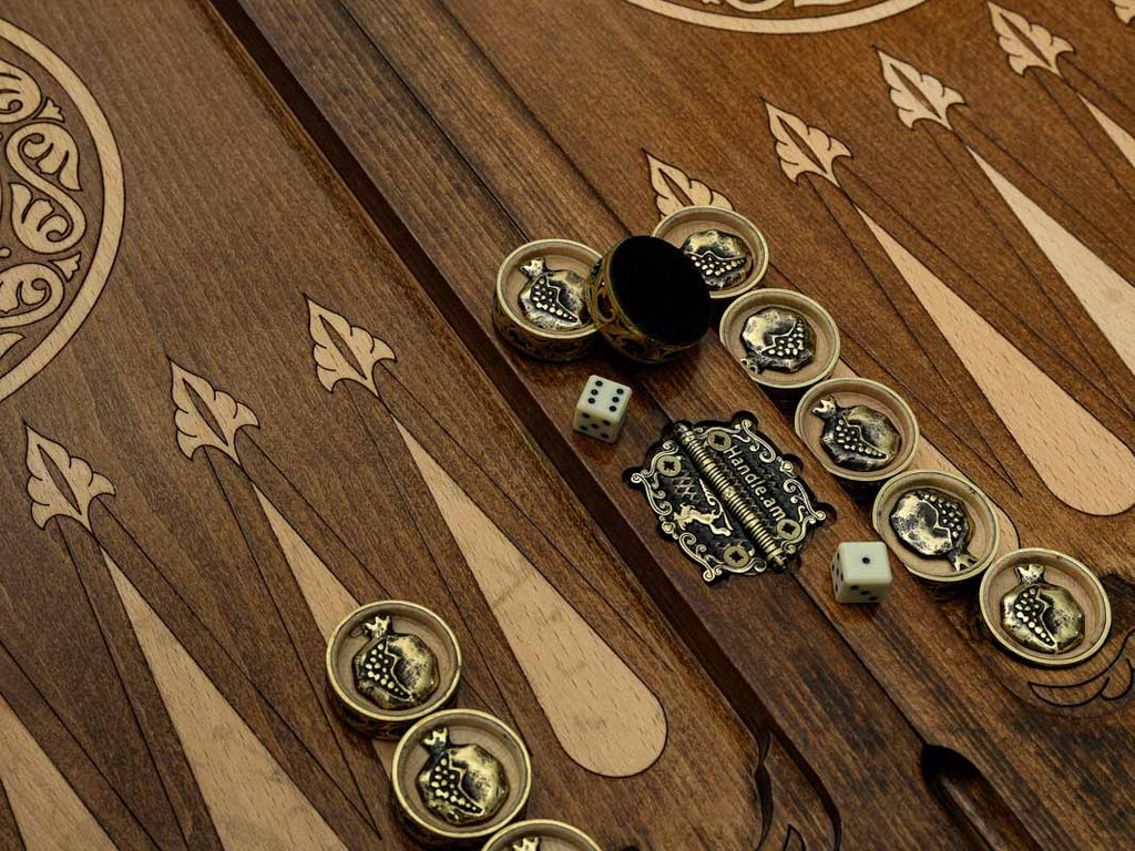Close-up of the bronze-topped checkers, dice and cup on the pomegranate table