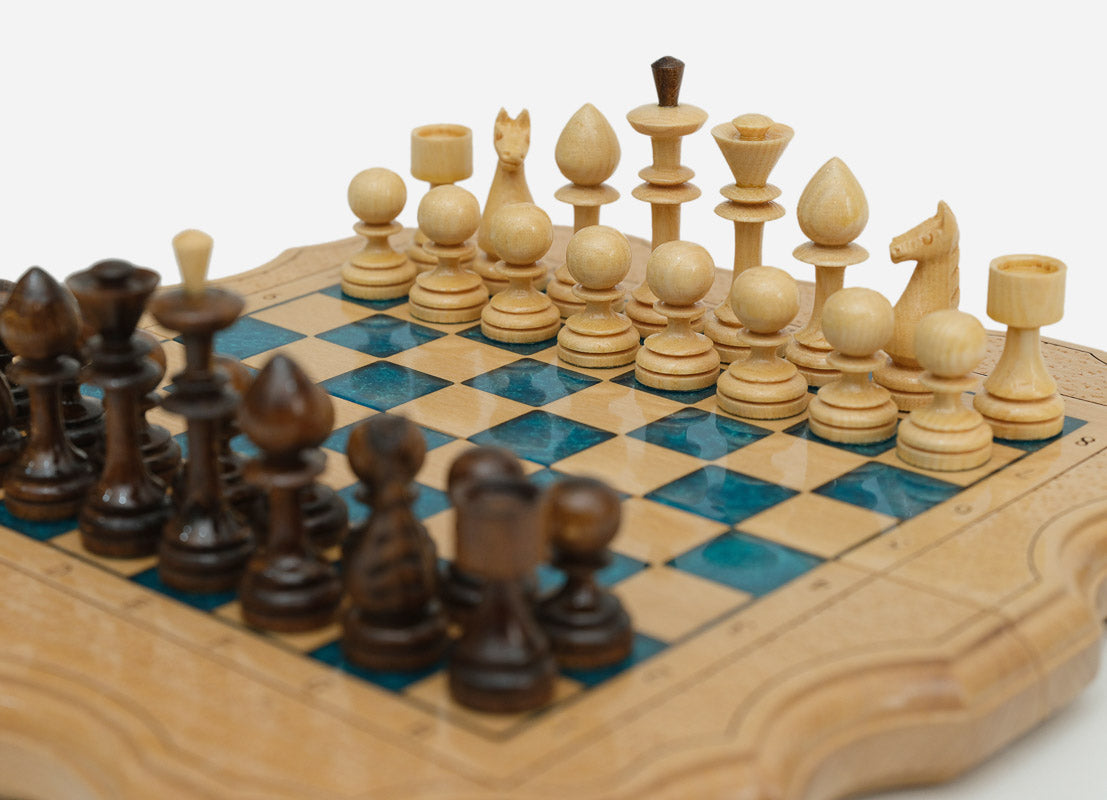 Overhead view of the blue epoxy chess board with the full set of 32 wooden pieces