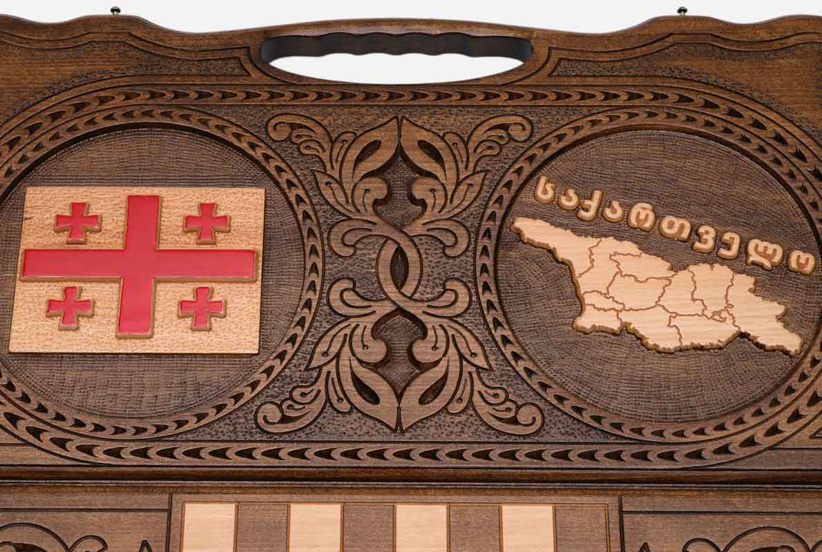 Angled view of the handmade Georgian backgammon set showing both carvings