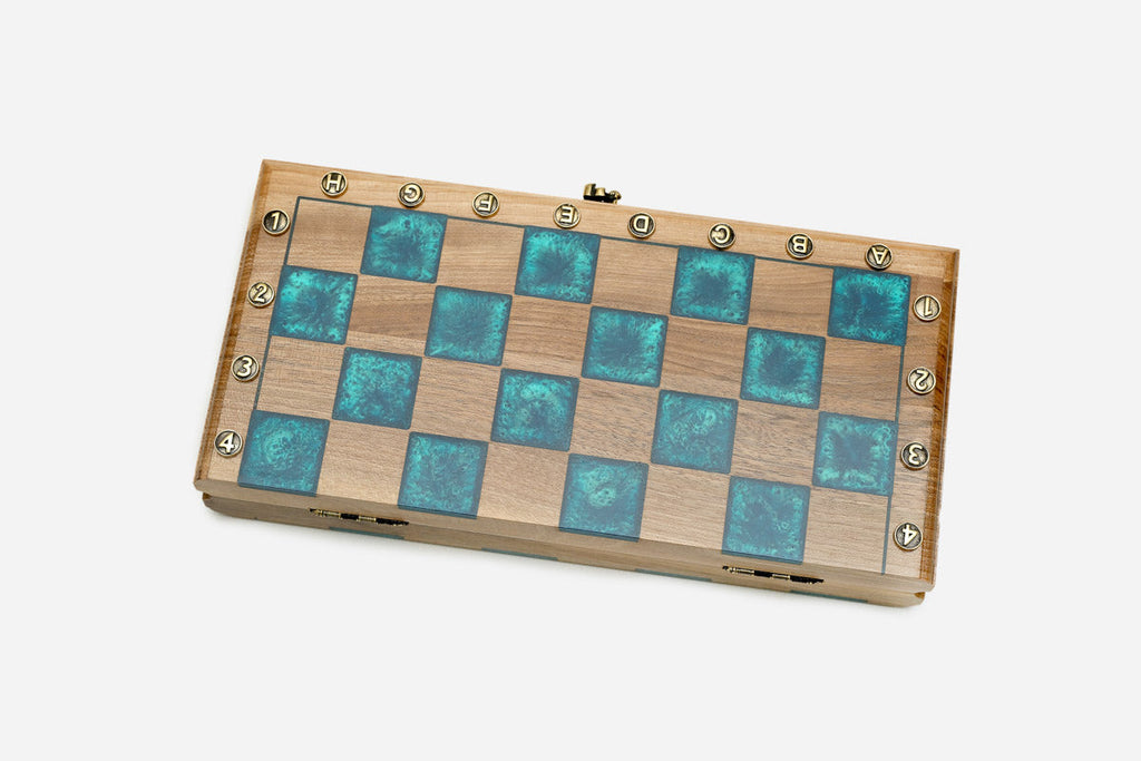 The folding walnut chess board shown closed on its turquoise epoxy face
