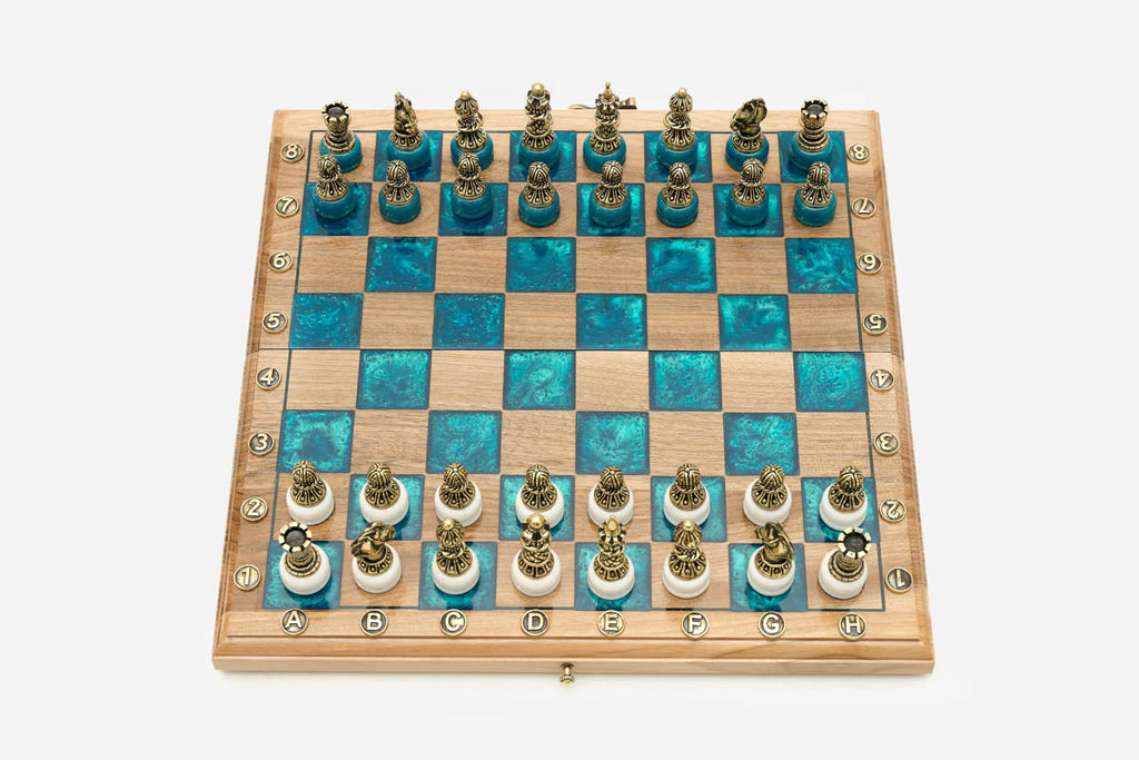 Angled view of the walnut and turquoise epoxy chess board with its bronze army