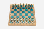Angled view of the walnut and turquoise epoxy chess board with its bronze army