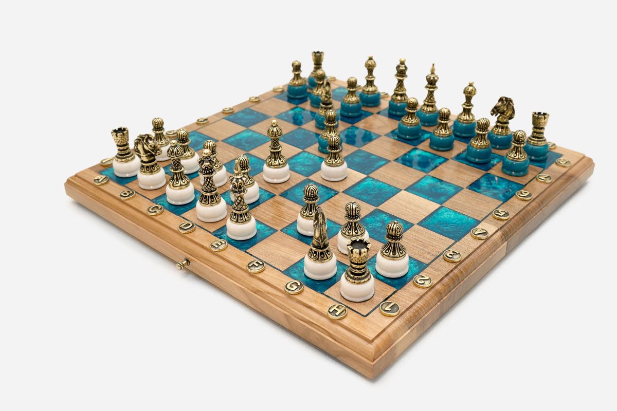 Close-up of the ornate cast bronze chess pieces on their white bases