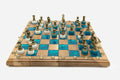 Luxury walnut chess set with marbled turquoise epoxy squares and ornate bronze pieces on white bases, set up for play