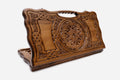 Carved Armenian backgammon board with a deep central ornament, interlaced panels and a cut-out carry handle, propped open
