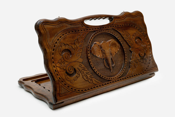 Hand-carved wooden backgammon board with an elephant and a cut-out carry handle, propped open