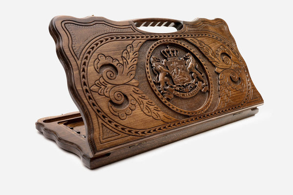 Carved beechwood backgammon board with the Georgian coat of arms at the center, propped open