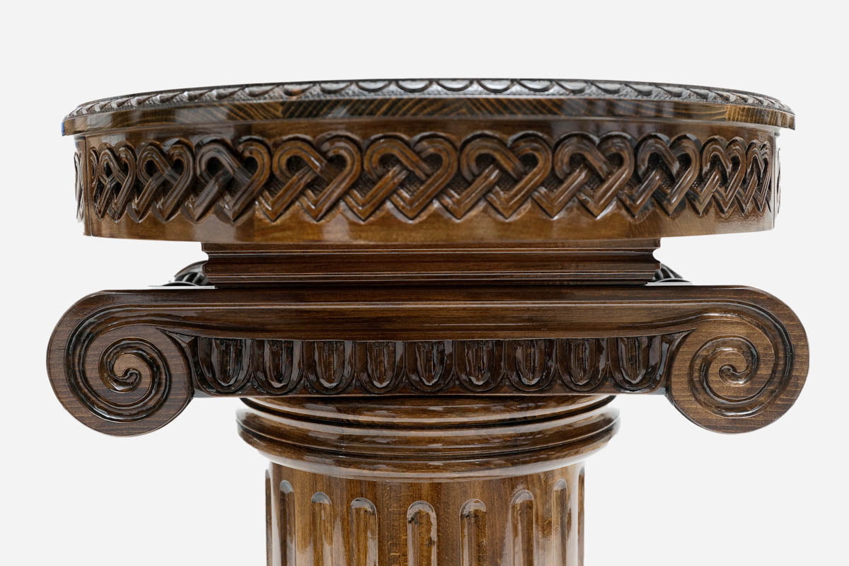 Detail of the hand-carved column capital supporting the round table top