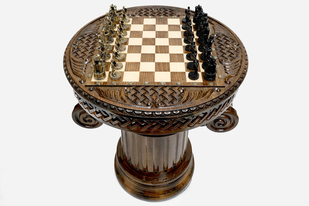 Overhead view of the round chess table showing the full board, interlace apron and figural metal armies