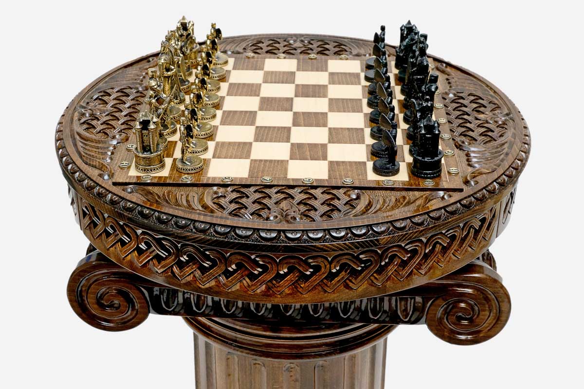 Angled view of the pedestal chess table set up for play with gold and black Crusader pieces