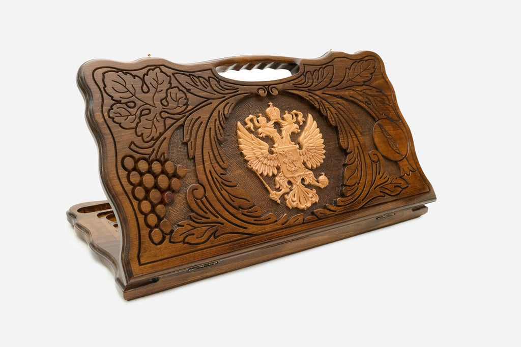 Carved Russian backgammon board with the double-headed eagle in a wreath of grapevines, cut-out carry handle, propped open