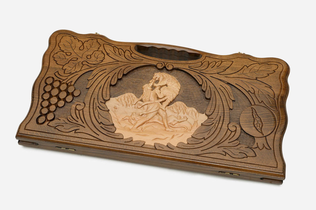 Angled view of the handmade backgammon set showing the carved scene