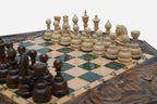 Close-up of the dark wooden chess pieces standing on the green epoxy board