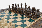 Close-up of the dark wooden chess pieces on the green epoxy board