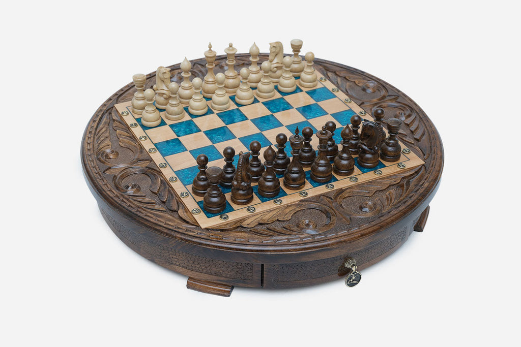 Full view of the round blue epoxy chess board with light and dark pieces in starting position