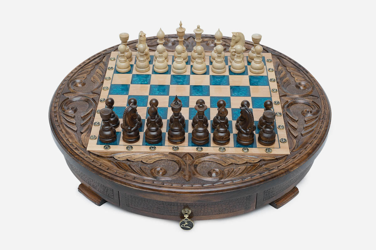 Round chess set with storage, turquoise-blue epoxy squares and turned wooden pieces set up for play