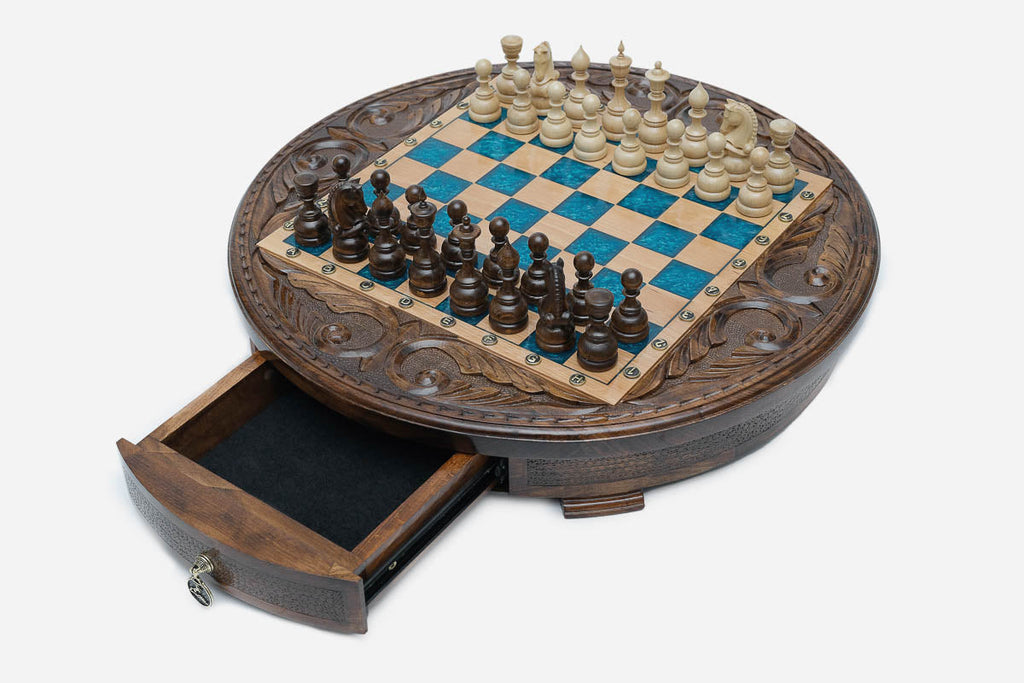 The round chess set with its storage drawer pulled open, showing the felt lining and brass pull