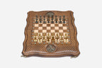 Top-down view of the Tree of Life chess set with gold and dark bronze figural pieces arranged for play