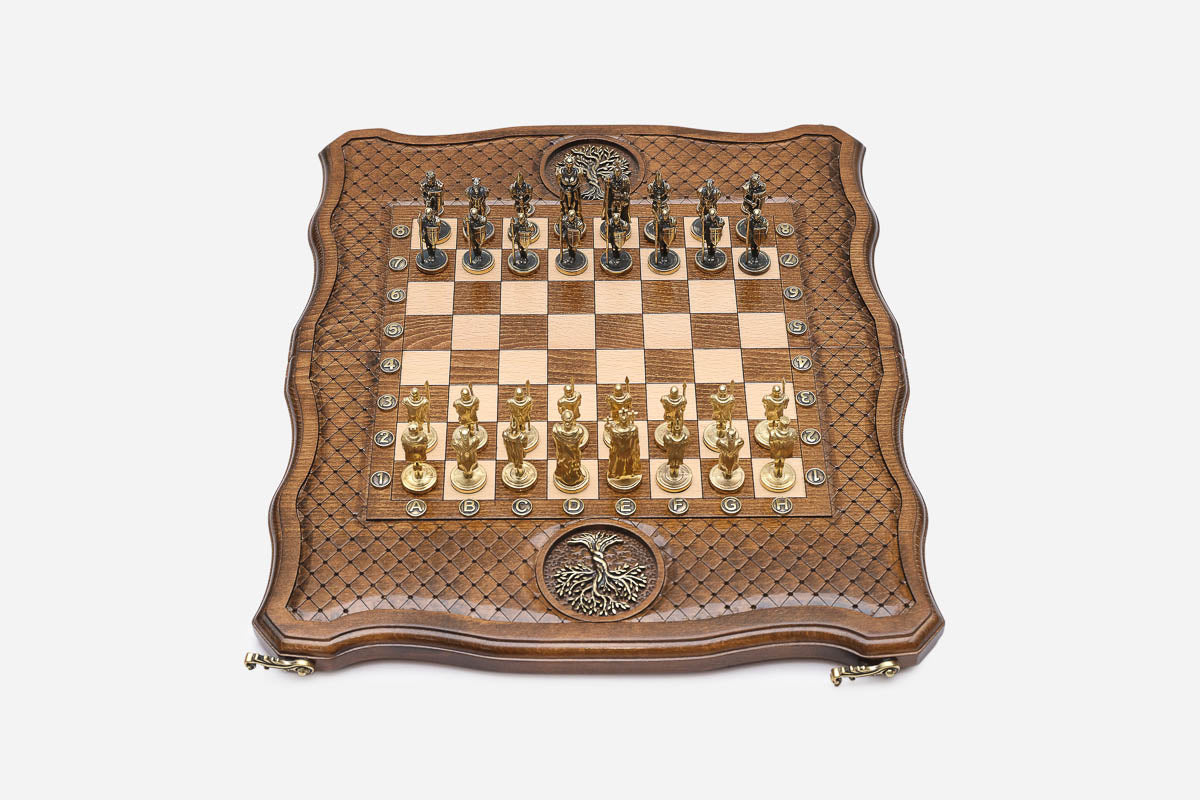 Top-down view of the Tree of Life chess set with gold and dark bronze figural pieces arranged for play
