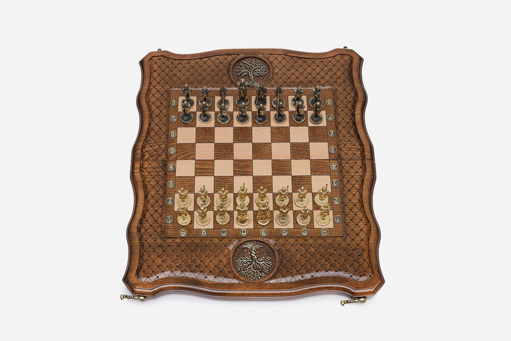 Overhead view of the carved board with cast-metal warrior pieces and bronze Tree of Life inlays