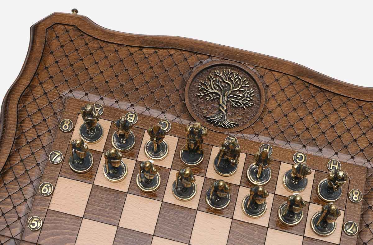 Close-up of the metal pawns beside the cast-bronze Tree of Life inlaid in the wooden frame