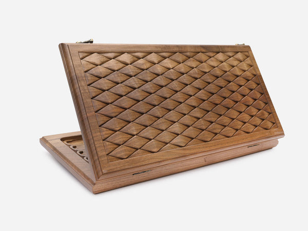 Folding walnut backgammon board with an all-over hand-carved diamond relief, shown open