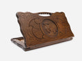 Hand-carved wooden backgammon board with symmetrical ornaments and a smooth centre, cut-out carry handle, propped open