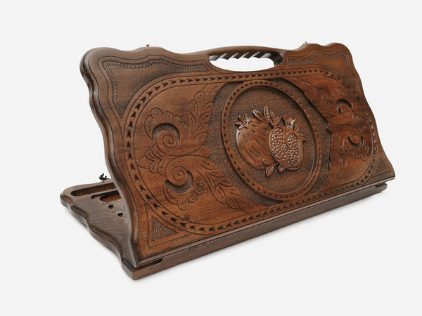 Carved beechwood backgammon board with a ripe pomegranate and a carry handle, propped open