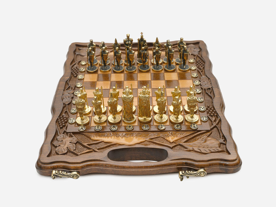 Walnut chess and backgammon set open to the chessboard with figural metal pieces