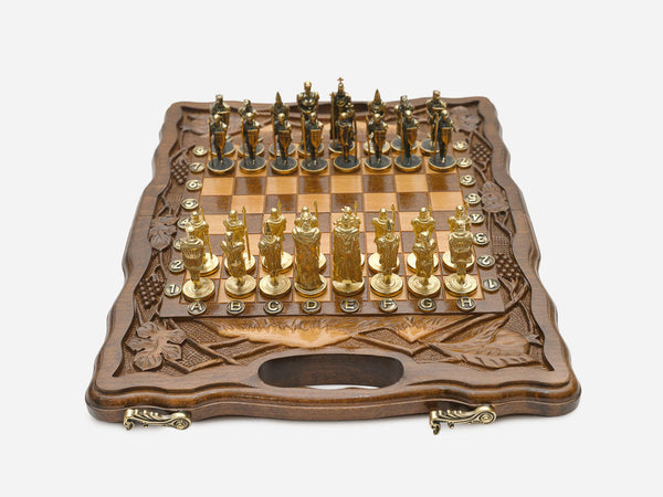 Walnut chess and backgammon set open to the chessboard with figural metal pieces