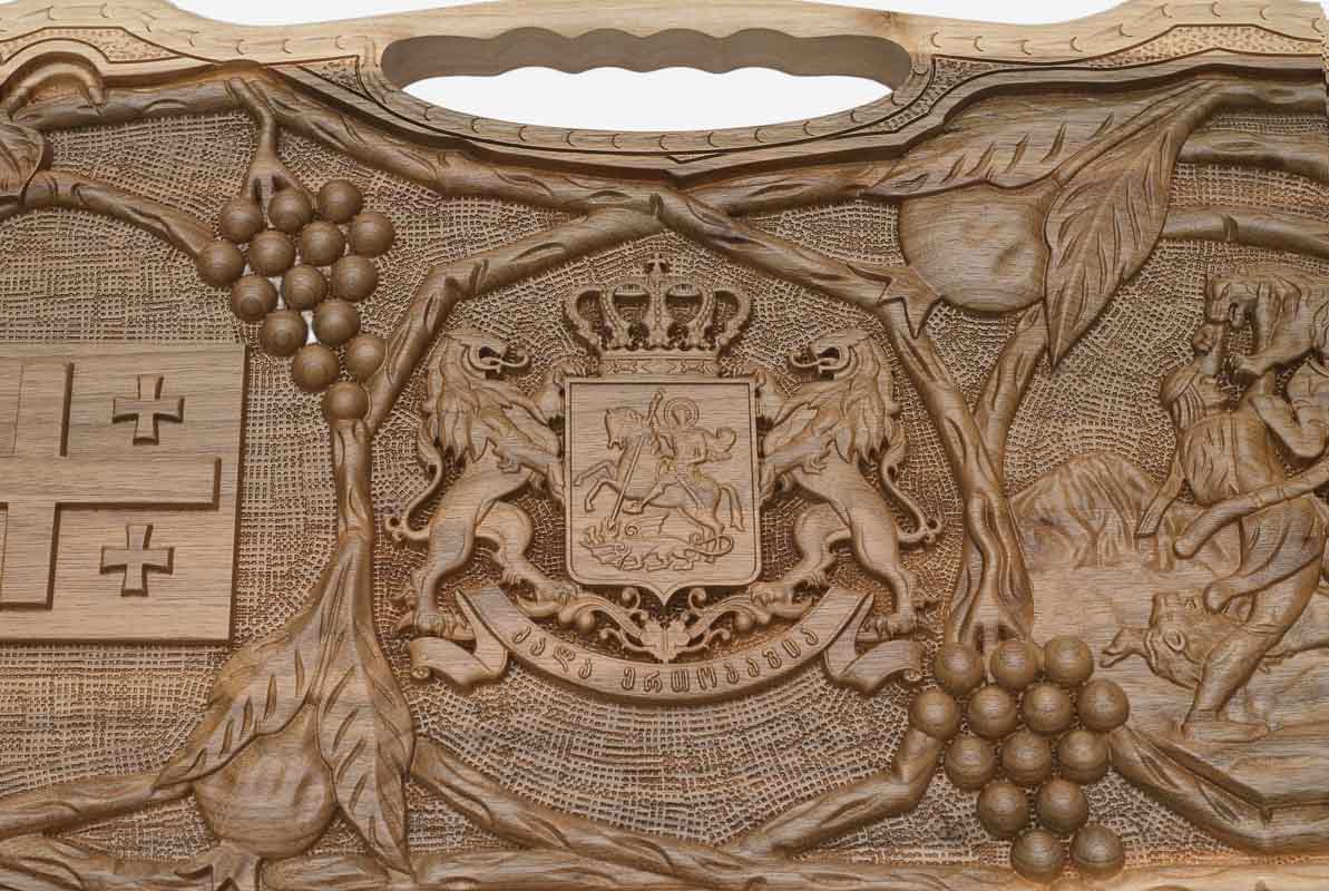 Detail of the carved grapevines wreathing both emblems