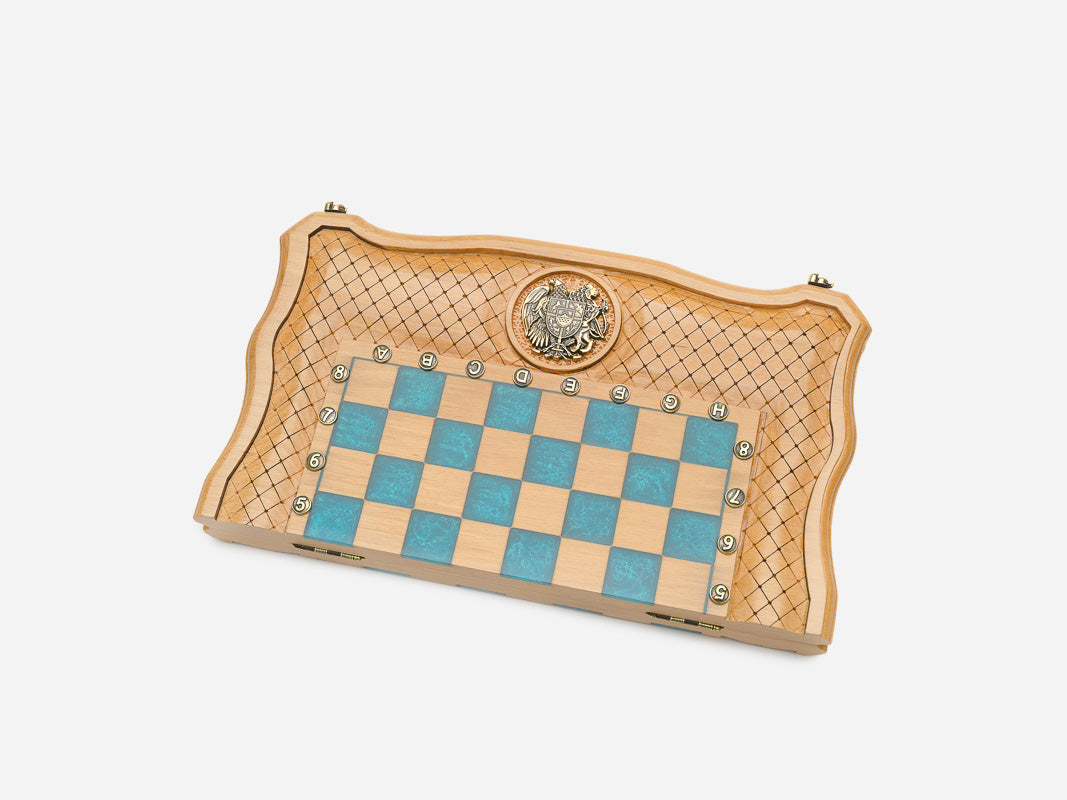 The opened turquoise epoxy chess board with its light and dark wooden pieces set up for play