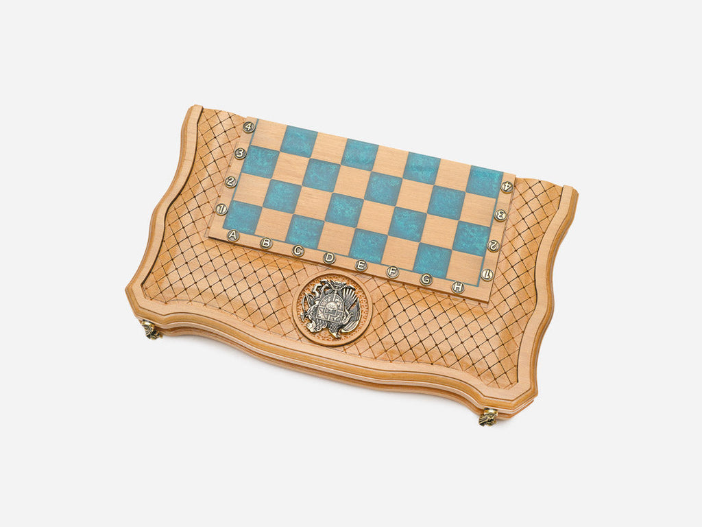 Angled view of the folding chess set showing the bronze coat of arms on the border