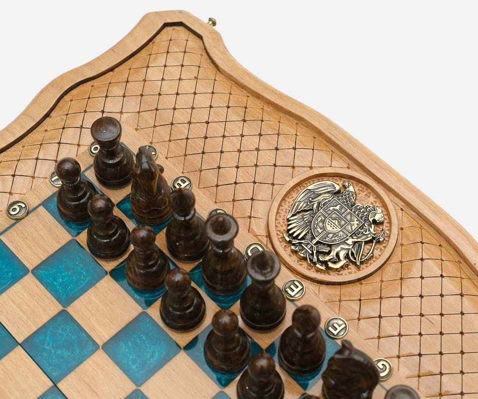 The dark wooden pieces beside the bronze coat of arms inlay